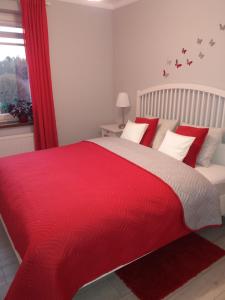 奥斯威辛Apartament FAMILY- klimatyzacja的一间卧室配有红色的床和红色毯子