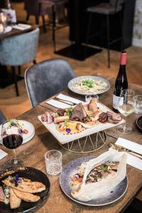 海牙'T古德霍夫特酒店的一张木桌,上面放着盘子和一瓶葡萄酒