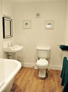 普尔赫利Rooms at Martha Jones的浴室配有卫生间、盥洗盆和浴缸。
