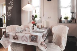 科斯费尔德Ferienwohnung Keull的餐桌、白色椅子和桌布