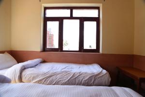 MuktināthHimalayan Paradise的一间卧室设有两张床和窗户。