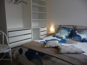 圣若里奥Le Rive Gauche的一间卧室配有一张带蓝色和白色床单及枕头的床。