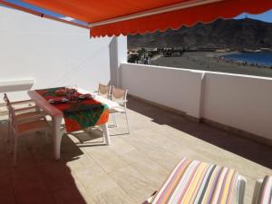 大塔拉哈尔ÁTICO EN PRIMERA LINEA DE PLAYA的海滩景阳台配有桌椅