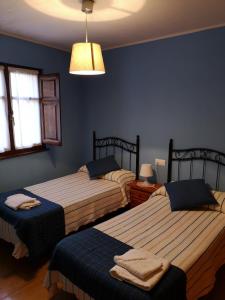 涅姆布罗Casa Guela Niembro的卧室设有两张床铺和蓝色的墙壁