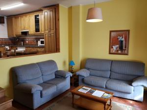 涅姆布罗Casa Guela Niembro的客厅配有2张蓝色的沙发和1张桌子