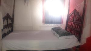 拉穆Wildebeeste Lamu的一间小卧室,配有一张带窗户的床