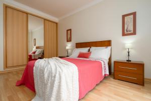 波尔蒂芒Cozy Apartment PORTIMÃO City Center的一间卧室配有一张带红色毯子的大床