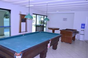 瓜鲁雅Ap Enseada Lado Praia Ar Cond Piscina Wi-Fi 500Mb的台球室设有台球桌和台球桌