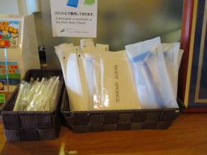 仙台绿井酒店的一张桌子上装满塑料用具的黑色篮子