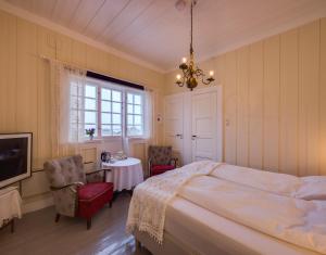 勒丁恩Arctic Garden的一间卧室配有一张床、一张桌子和一个吊灯。