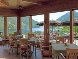 魏森湖魏森塞纳格勒霍夫酒店的餐厅配有桌椅,位于山脉的背景中