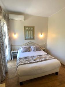 勒拉旺杜Hôtel Méditerranée的卧室配有一张带两个枕头的大白色床