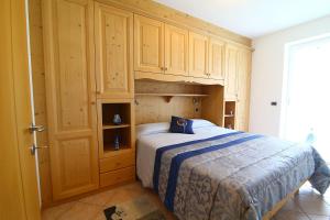 费德拉帕加内拉Paradise Apartments Paganella的一间卧室配有一张床和木制橱柜