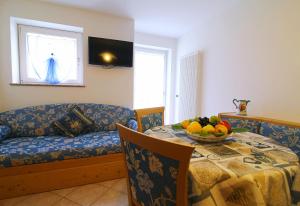 费德拉帕加内拉Paradise Apartments Paganella的客厅配有沙发和带一碗水果的桌子