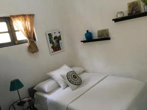 圣多明各Chao Mamá Hostal的一间卧室设有两张白色的床和窗户