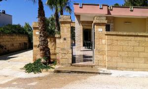 托雷圣乔万尼乌Casa vacanze Consiglia的一座石头建筑,前面有棕榈树