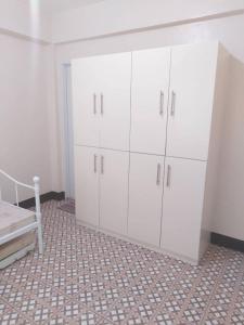 塔比拉兰JMC Residence的卧室配有白色橱柜和1张床。