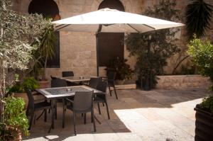 耶路撒冷Gloria Hotel的庭院内桌椅和遮阳伞