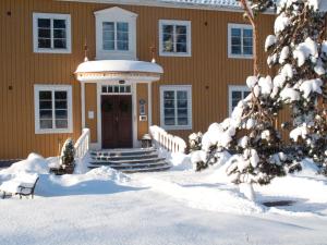 InsjönInsjöns Hotell的前面的地面上积雪的房子