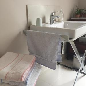 Le Minihic-sur-RanceLa Maison Les Mimosas的浴室设有水槽和椅子上的毛巾