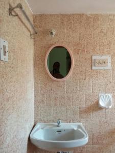 比纳里姆J & B Holiday Homes的一间带水槽和圆镜子的浴室