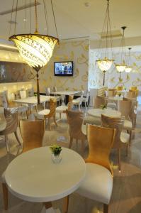 芦竹尊爵天际大酒店的餐厅配有白色的桌椅和灯光