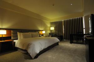 芦竹尊爵天际大酒店的酒店客房设有一张大床和一张书桌。