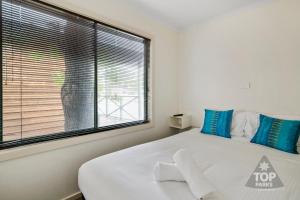 谢珀顿Shepparton Holiday Park and Village的一间卧室设有一张大床和一个大窗户