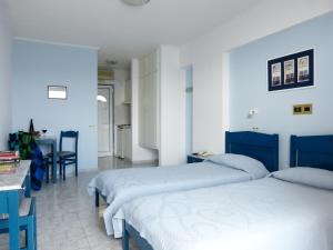 Katarráktis奥斯特里亚海滨公寓式酒店的一间卧室配有两张床和一张桌子及椅子
