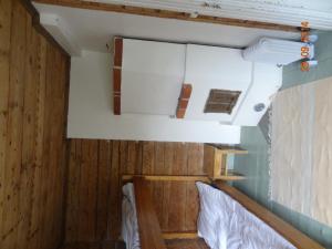 萨洛Vuohensaari Camping Ahtela's cottage的一间设有木墙的客房和一张位于客房内的床