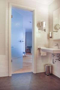 卡尔斯鲁厄SEEGER Living Premium West的一间带水槽、镜子和门的浴室