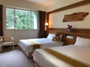 鹿谷乡孟宗山庄大饭店的酒店客房设有两张床,中间有一个泰迪熊