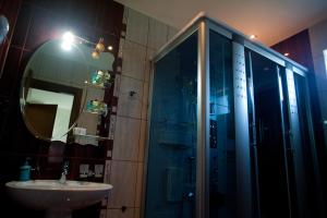 贝拉内卢卡酒店的带淋浴、盥洗盆和镜子的浴室