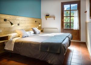埃乔Hotel de Montaña Uson的一间卧室配有一张大床和木制床头板