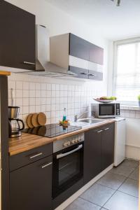 吕贝克奥贝查弗酒店的厨房配有黑色橱柜和炉灶烤箱。