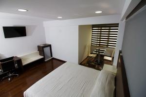 科恰班巴里贾纳公寓酒店的一间卧室配有一张床、一张书桌和一台电视