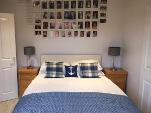 Obinan3A Mellon Udrigle的一间卧室配有一张带枕头的床,墙上挂有图片