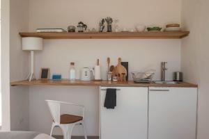 奥德赛克斯Alma Cheia Sunrise Studio Apartment的厨房配有带桌椅的白色橱柜