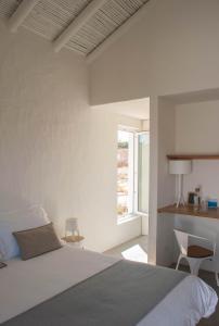 奥德赛克斯Alma Cheia Sunrise Studio Apartment的白色的卧室设有床和窗户