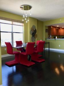 德通纳海滩海岸Opus Condominiums的一间用餐室,配有红色的椅子和桌子