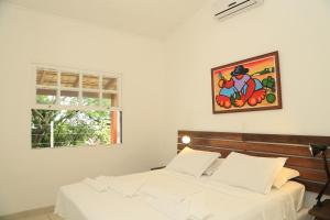 伊利亚贝拉Chalés Mariolinha的卧室配有两张床,墙上挂着一幅画