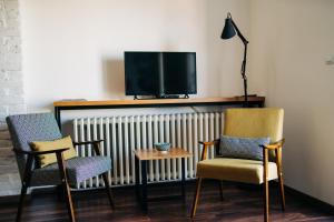 诺维萨德NS center apartment的客厅配有3把椅子和电视