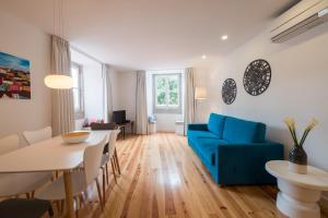 里斯本Sunshine House - Exclusive Apartment - Home By The Castle的客厅配有蓝色的沙发和桌子