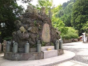伊势原市东学坊日式旅馆的公园里的石头喷泉,上面有雕像