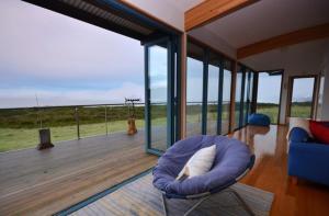 South BrunyMures Cloudy Bay Retreat的客厅设有一张位于甲板上的蓝色椅子