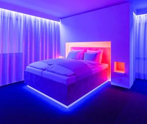 阿豪斯smartel at The Unbrexit的紫色卧室配有一张带粉红色枕头的大床