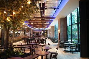 首尔Orakai Cheonggyesan Hotel的餐厅设有桌椅和大窗户。