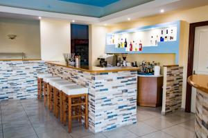 Kyra PanagiaKyra Panagia Hotel的餐厅设有酒吧,铺有白色和蓝色的瓷砖