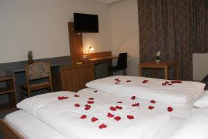 利恩茨Dolomitenhotel Lienz的一间设有两张红色玫瑰床的房间