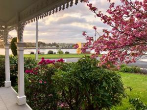 德文港Riverbank villa的一个带粉红色花卉的门廊和凉亭